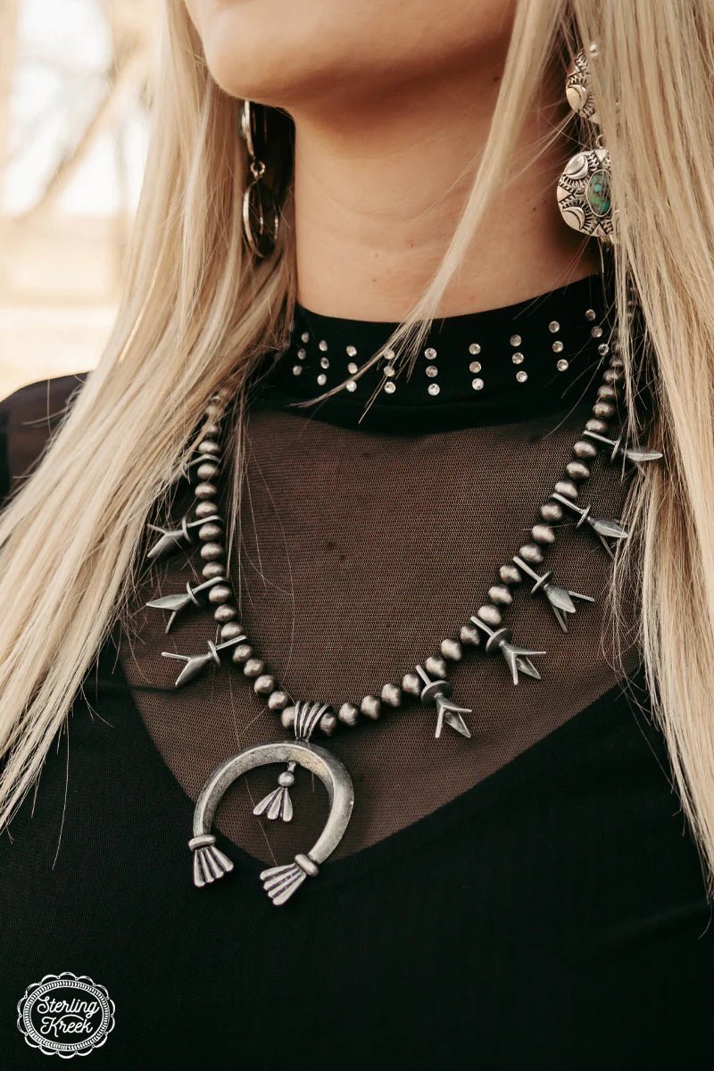 Get ready to wrangle your style with the Tribal Cowgal necklace! Featuring trendy navajo pearls and a lucky silver horseshoe dangle, this unique piece will add a playful touch to any outfit. So saddle up and add a touch of charm to your wardrobe with this must-have accessory. Yee-haw!   Length 13"  3" adjustable chain 