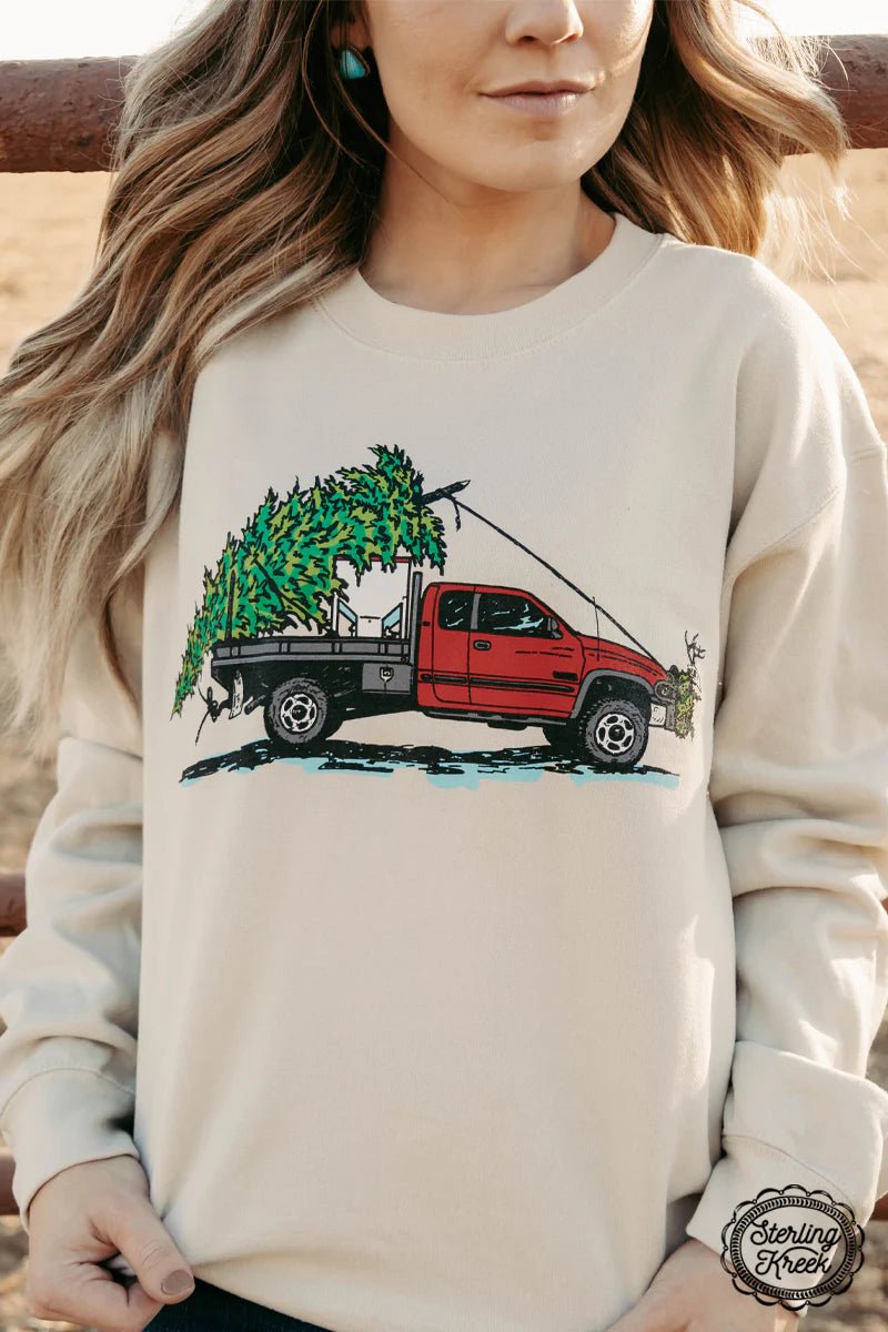 Climb into the holiday spirit with this cream Farm Truck Christmas Sweater! Decked out with a jolly feed truck towing a Christmas tree, plus a cow skull for a little extra Western flair, you'll be a festive hoot at the company holiday party!  50% Cotton 50% Polyester