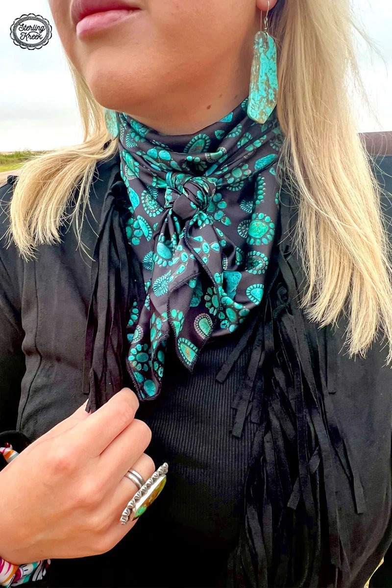 Hit the red dirt in style with the Concho Kreek Wildrag! This statement piece features a black wildrag with sparkling turquoise conchos, guaranteed to turn heads in the countryside. So switch up your style and give your look a lil' southern charm!  O/S  LENGTH: 34" X 34"