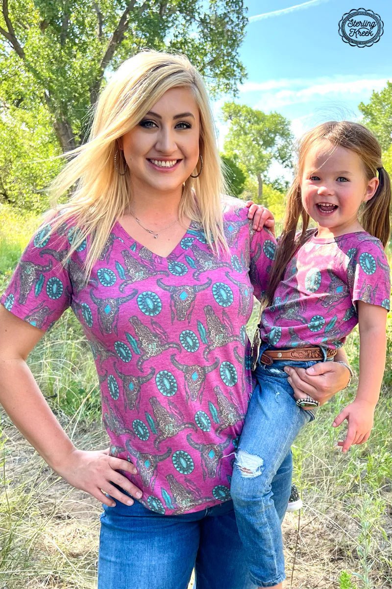 Be the most stylish wild child around in this Wild Thing Top! Made with a soft pink v-neck and rocking cheetah cow skulls with turquoise conchos, you'll be turning heads and making a fashion statement. Unleash your wild side!     55% cotton 40% polyester 5% spandex   Measurements are with shirt laid flat 