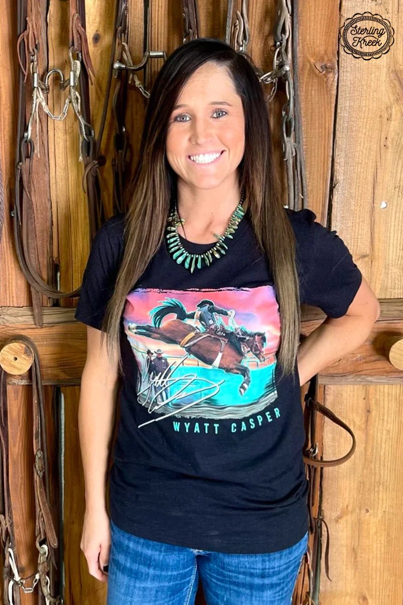 Be ready for one wild ride with this stylish "Wishin' Wyatt Luck Tee"! Featuring a black tee with a picture of bronc rider Wyatt Casper, you'll look like you just stepped off the rodeo ring. Show off your unique style with this one-of-a-kind piece! Yee-Haw!  90%COTTON 10% POLYESTER
