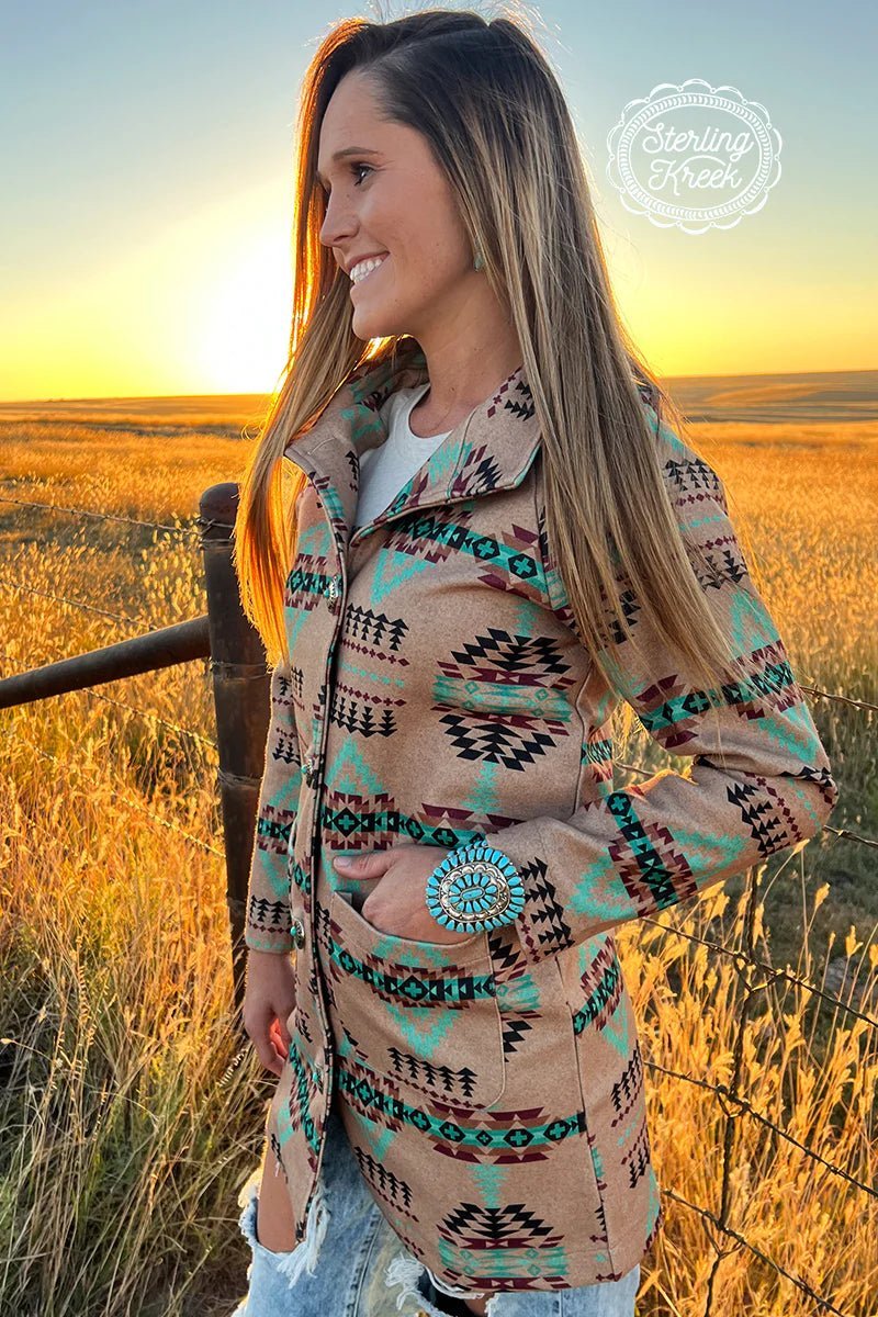 The Colorado Sunset Jacket is a Gorgeous Mocha Colored longer Jacket with a multi colored Aztec Print Pattern and Beautiful Turquoise Concho Buttons. This Jacket is 32" in total length from the shoulder to bottom. It has double open pockets on the front. The colors paired in this jacket are Gorgeous!!!  93% Polyester, 7% Spandex  XS,S,M,L,XL