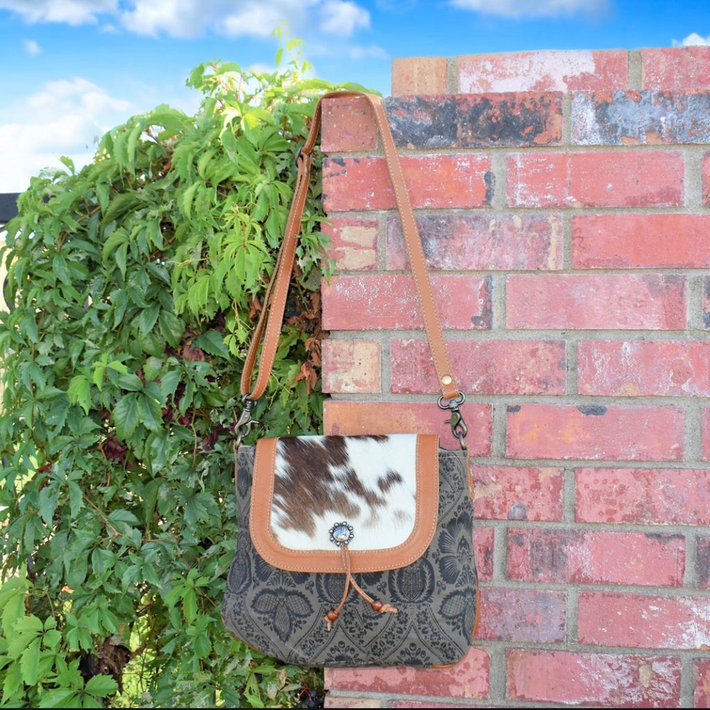 This Vintage detail canvas bag with hair on hide flap is perfect for a family outgoing or everyday use. The Bag can be used as a shoulder bag, crossbody, or short strap purse.  ***ALL HIDES WILL VARY***  11"H X 13"W  48" adjustable & removable strap