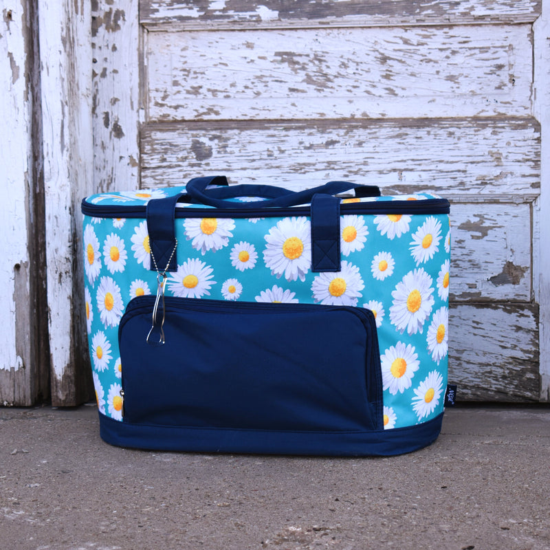 Sky blue with all over daisy vinyl insulated soft side oblong cooler bag with navy pockets, base, and handles.