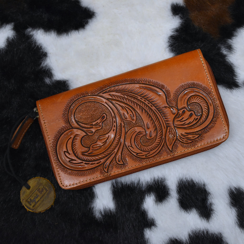 Rich cognac tan tooled leather wallet with all around zipper closure.