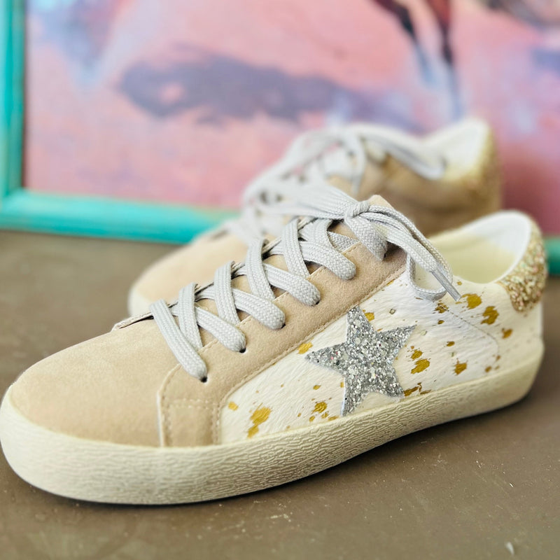 The Golden Cow Sneakers are adorable white and gold cow print with a silver glitter star on the side and tan toe. The sneaker has gold glitter back and grey shoe laces. The material of these sneakers will be easy to clean.