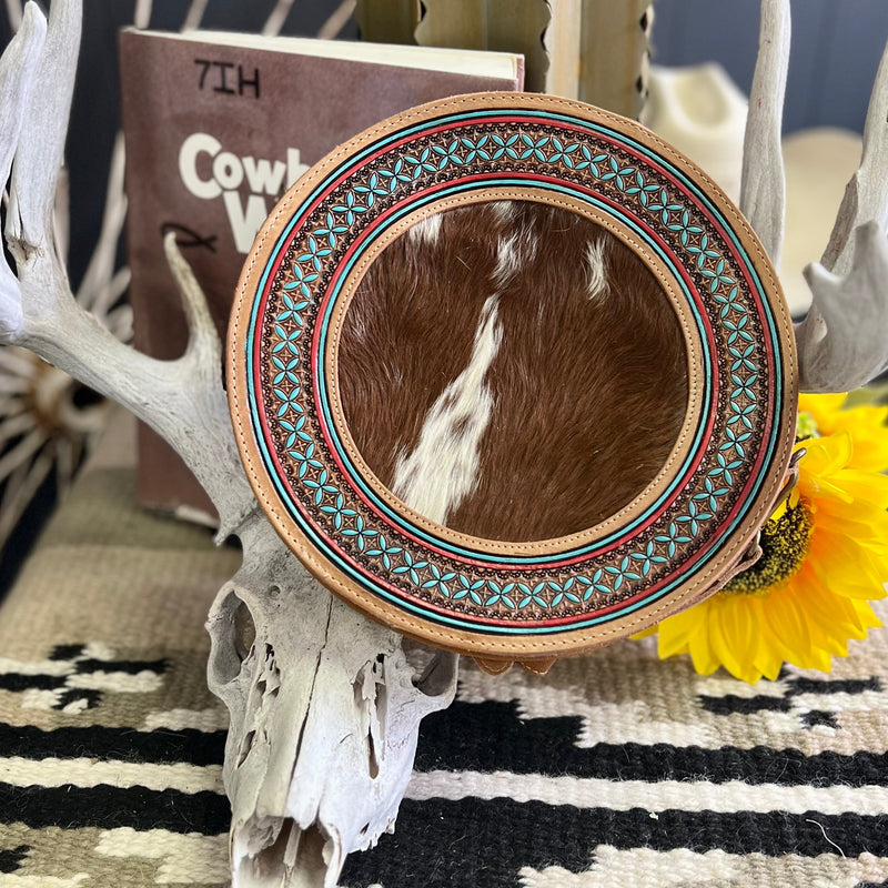 The Phantasm Round Canteen Bag  is a 10" round Hair On Hide with Beautiful Turquoise Aztec Tribal Accent. The bag features a 3/4 zipper closure and a small zipper closure on the back. The bag features 3 different cowhide variants.    10" round in size and 2" in Width  43" adjustable strap 