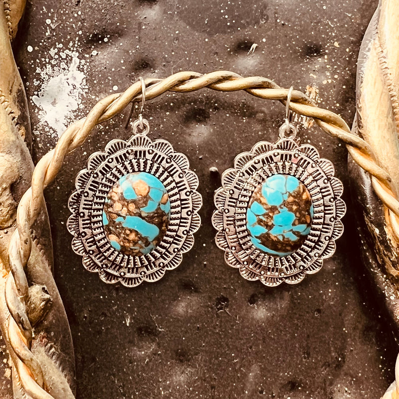 The Sophisticated in Turquoise  Earrings are a around concho cutout with handmade brown and turquoise stones.  The Concho cutouts are stamped with different designs to make these earrings have tons of character.  They are 1 1/2" in Diameter.   The stones in these earrings make these so subtle and beautiful.  They have a fish hook back.
