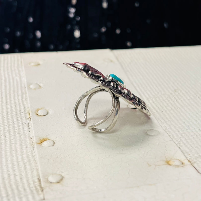 The Oval Platter Ring is a Western Concho Style cuff ring. The ring is 1" W X 2" L.  It is super light weight and can be adjusted to fit any size finger. Super Cute!! The beautiful Concho Style with the small turquoise stone is amazing. 