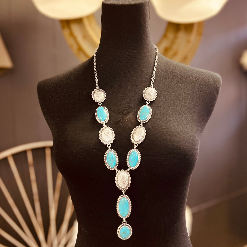 The Perfect Pair Necklace is a 34" silver necklace with alternating 1" concho &  turquoise stones on each side and a 4" stone dangle drop stones as the Pendant.  *matching concho earrings included*