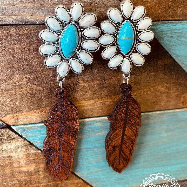 These earrings are the perfect addition to your jewelry box! These are a white buffalo stones and turquoise center stone with a leather feather dangle!   Length: 3"