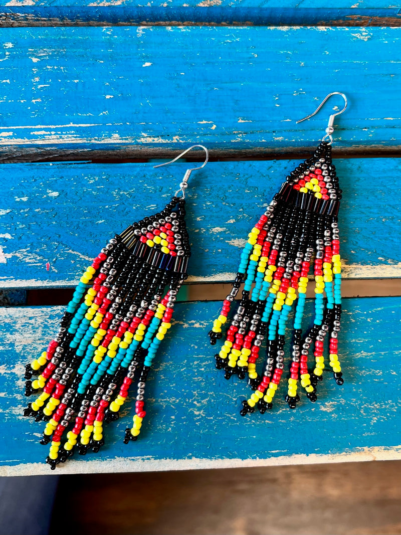 The Comanche Seed Bead Earrings are a multi bead, multi strand, Aztec design dangle design. The colors really stand out and would add tons of color to any outfit. The total length of the earrings a 3 1/2".