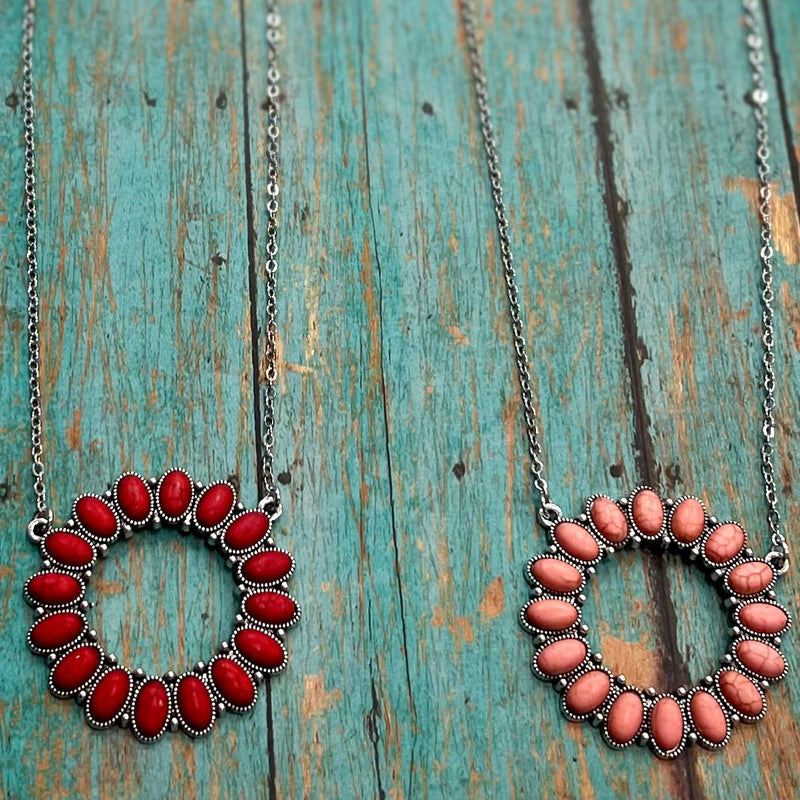 Step into the wild west with our Ring of Fire Necklaces! This stylish open pendant necklace features a unique 'ring of fire' composed of natural stone in beautiful shades of red and pink. With one of these showstoppers hangin' off your neck, you'll be ropin' in compliments left and right! So gallop on down and saddle up with this sizzlin' western look!