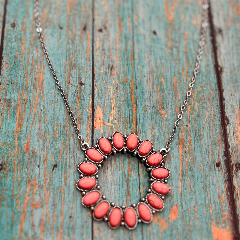 Step into the wild west with our Ring of Fire Necklaces! This stylish open pendant necklace features a unique 'ring of fire' composed of natural stone in beautiful shades of red and pink. With one of these showstoppers hangin' off your neck, you'll be ropin' in compliments left and right! So gallop on down and saddle up with this sizzlin' western look!