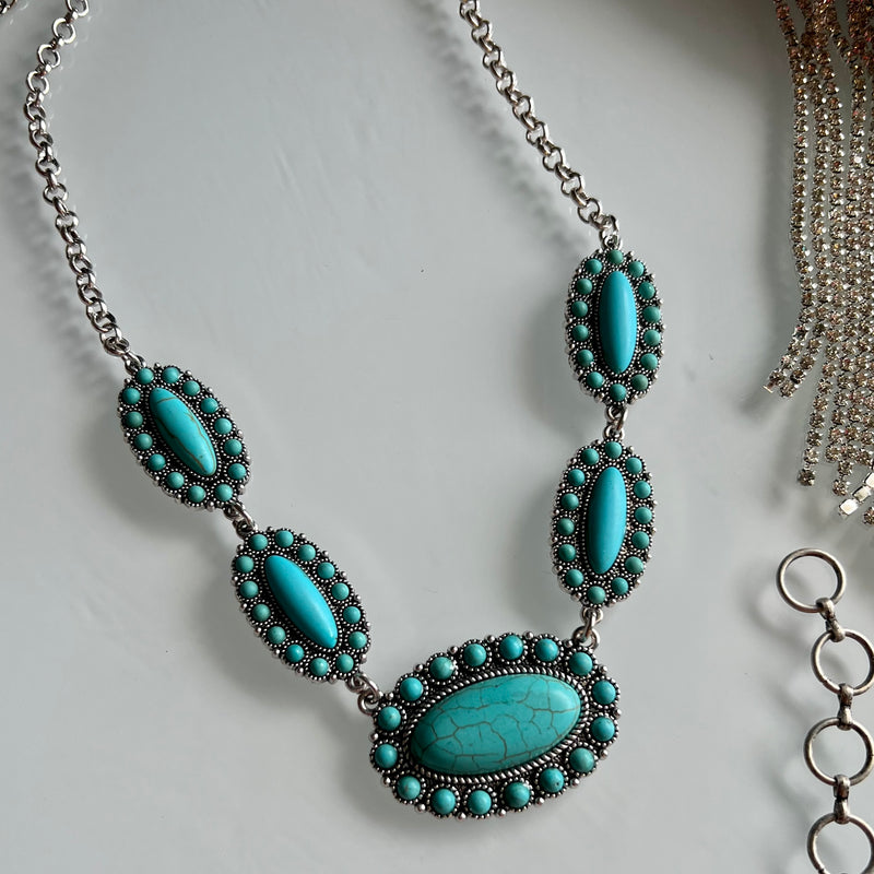 Dare to stand out with the Prim And Proper Turquoise Necklace. Featuring a bold western concho turquoise stone, this chain necklace will empower you to be daring and stylish. Make a statement and show the world you're not afraid to take risks.  Material: zinc, brass, rhodium plated, stones lead compliant, nickel free to prevent tarnish. 