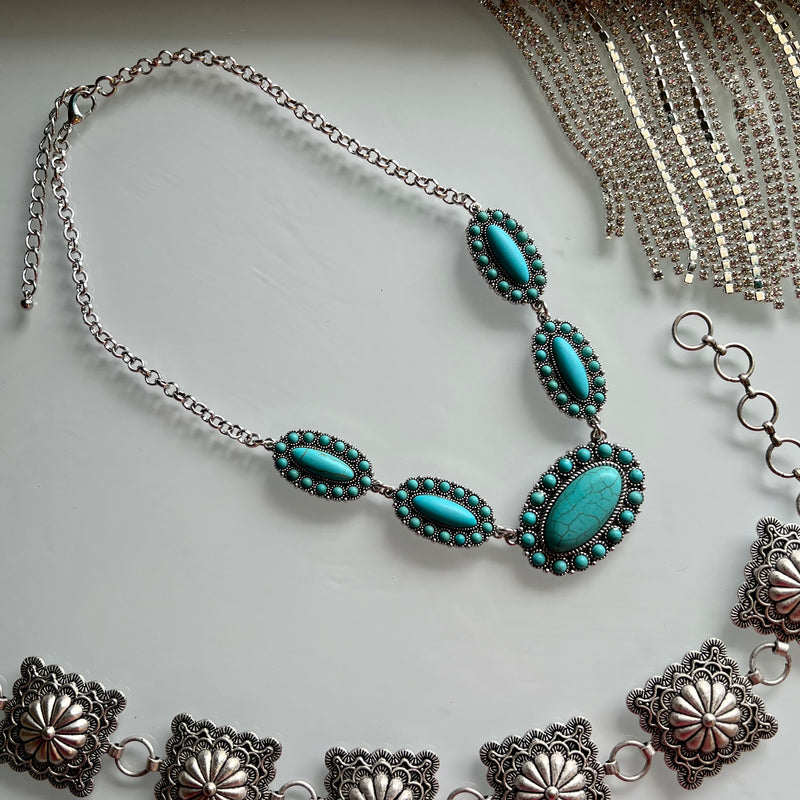 Dare to stand out with the Prim And Proper Turquoise Necklace. Featuring a bold western concho turquoise stone, this chain necklace will empower you to be daring and stylish. Make a statement and show the world you're not afraid to take risks.  Material: zinc, brass, rhodium plated, stones lead compliant, nickel free to prevent tarnish. 