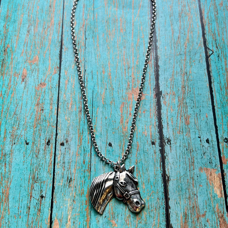 A Girl Who Loves Horses Necklace is a western inspired horse pendant necklace approx. 18" long. The Horse Pendant is 1" in total diameter.  Material: zinc, brass, rhodium plated lead compliant, nickel free to prevent tarnish. 