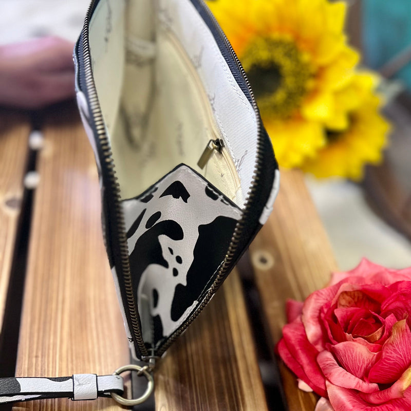 Black and white cow print wristlet crossbody bag western style This versatile bag, made of durable fabric has an expandable feature that allows for extra storage. Features a removeable wristlet strap and a crossbody strap. Whether you're going out for the day or a night on the town, it's the perfect companion for your travels.