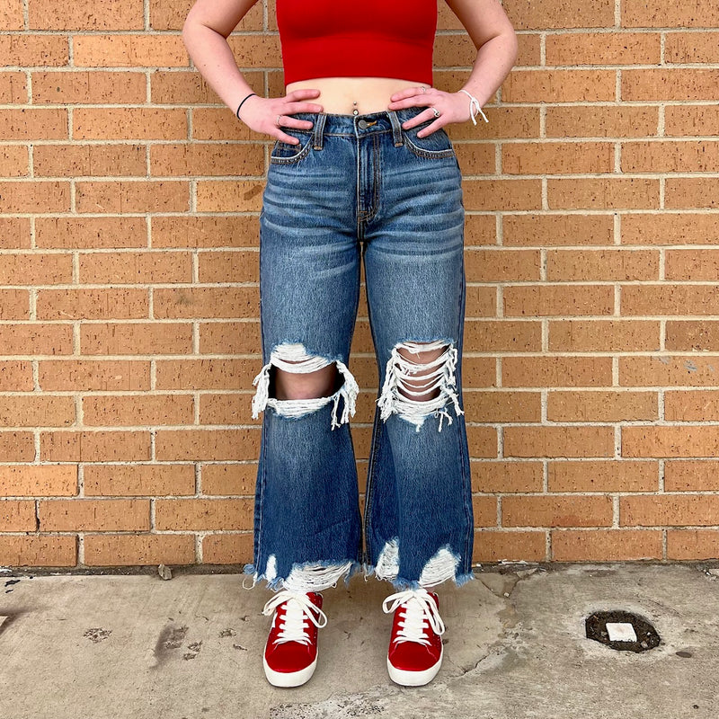 The Clenched Up Jeans are perfect for anyone looking to add a distressed, yet comfortable flair to their wardrobe. These cropped jeans offer a snug fit that won't compromise comfort. With a versatile design that looks great paired with any style, these jeans are sure to become a staple in your closet.  100% Cotton  **Model is wearing a size 25.**