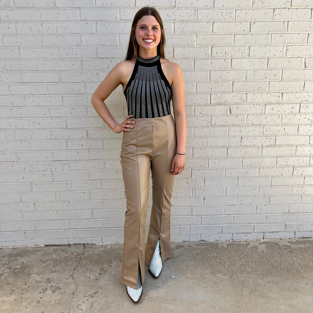 Stay comfortable and stylish in these Faux Leather Front Slit Flares. With their high rise and wide leg, these pants are designed to create a flattering silhouette. The faux leather detailing and front slit offer a subtle yet edgy look. Available in Black and Khaki for versatile styling options.  100% Polyester