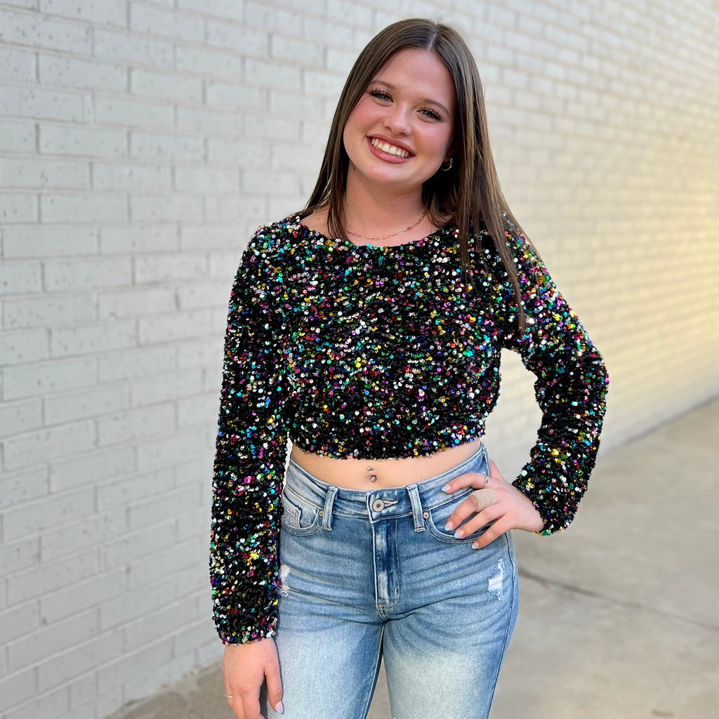 The Wildest Dreams Top is perfect for any night out. Crafted from a black top with sequin pattern, this cropped blouse features a lantern sleeve and an eye-catching multi-colored design. Add a touch of shine to your wardrobe with this stylish statement piece.