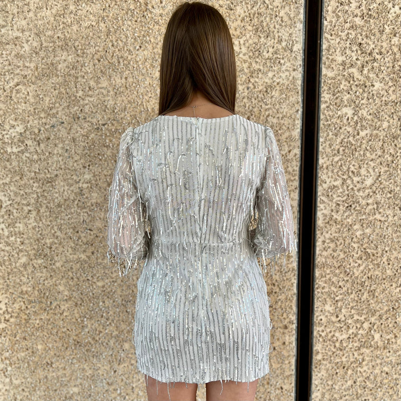 Look glamorous in our Time Square Party Dress. Crafted with a vneck and finished with shimmering silver sequins, this long sleeve mini dress is just what you need for that special event. Tassel details make this white party dress a stand-out while still ensuring you turn heads and look amazing.