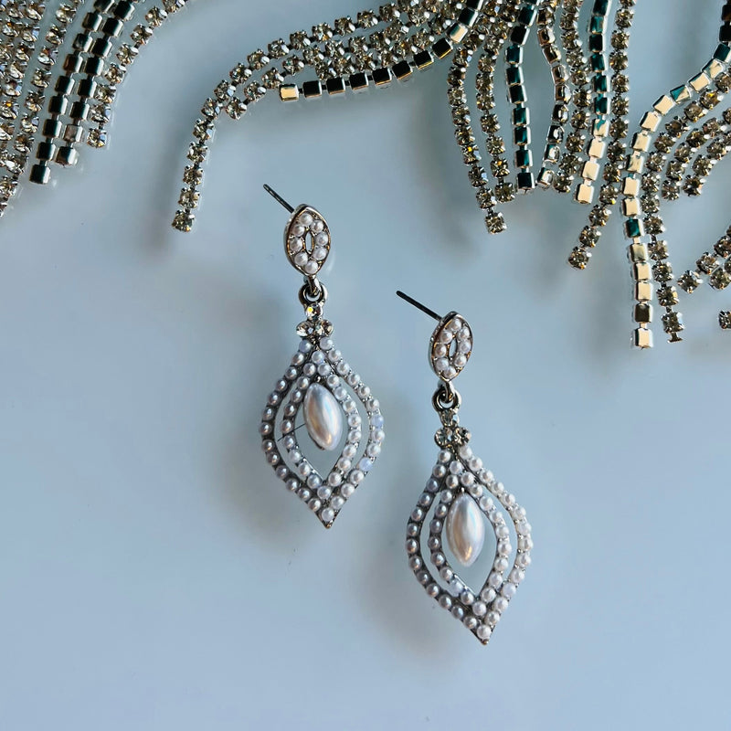 Before the Stroke of Midnight Earrings are the perfect combination of classy and stylish. With a dangle, tear drop shape and pearls suspended from sterling silver, these earrings will make a statement at 1 3/4" length. Step out in style and make a lasting impression.