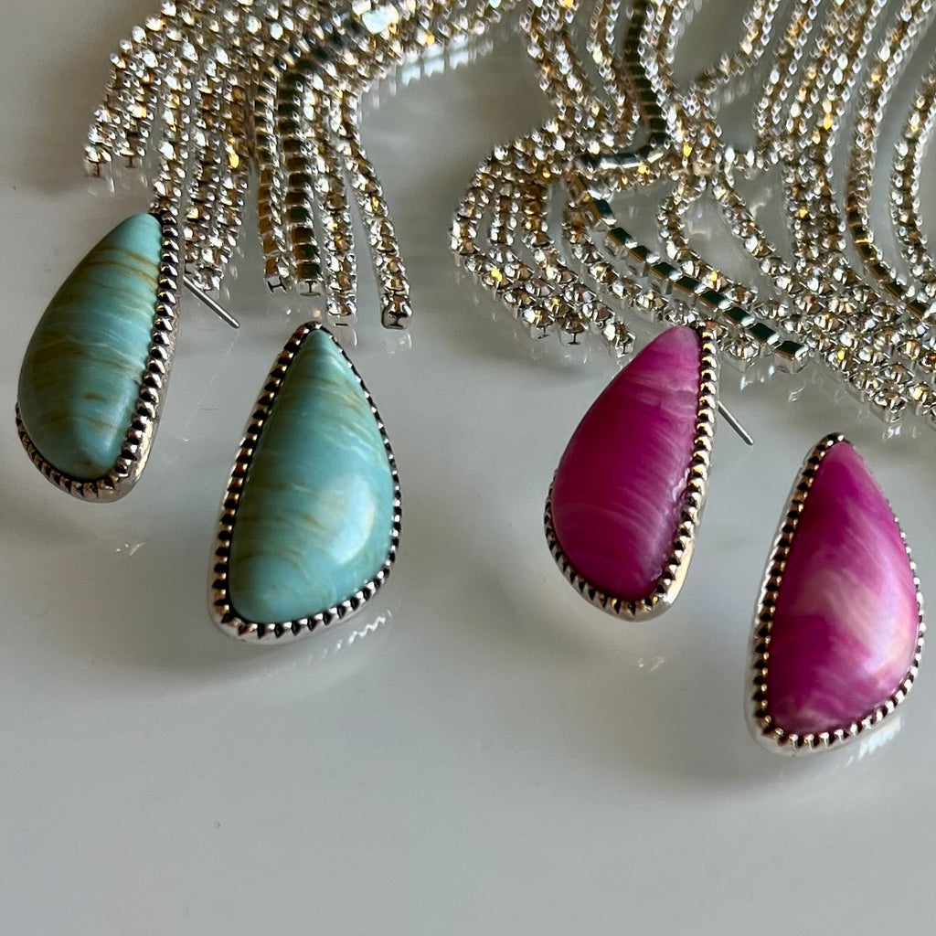 These chic Simple Stone Earrings are perfect for everyday style. Crafted with a triangular agate stone, available in pink or turquoise, and featuring a post back stud and a high-polish silver finish, these earrings will add subtle glamour to your look.