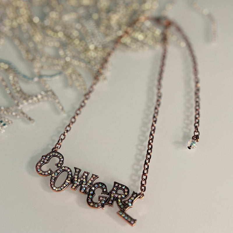 This striking Copper CowGirl Necklace is perfect for any fashionista. It features a high polish copper finish and iridescent rhinestones for added sparkle. It also has a 3" CowGRL Message Pendant, and a 6" chain with an adjustable 5" lobster clasp. Get yours today for a stunning update to any outfit.