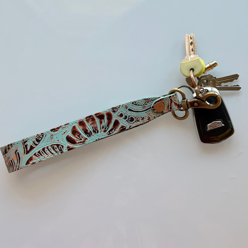 This beautiful Path Flower Trail Key Fob offers a classic look with a modern twist. Made of genuine tooled leather, this key fob features a pattern of turquoise and brown to add an elegant touch to any set of keys. At 10" in length, it's the perfect size to clip onto your bag or belt loop.