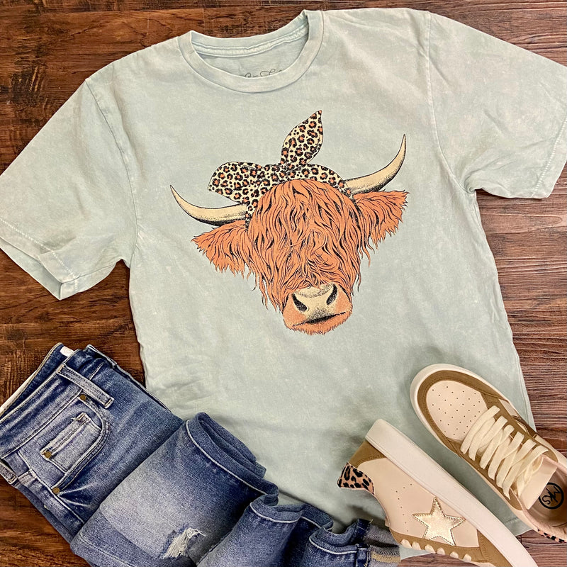 The Mint Highland Cow Mineral Washed Tee is a Mint Green Colored loose fit tee featuring an open neckline and slightly dropped sleeves. The Highland Cow design in a free handed drawing and is so precious!  100% Cotton mineral washed