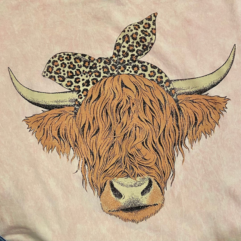 The Pink Highland Cow Mineral Washed Tee is a Pink colored loose fit tee featuring an open neckline and slightly dropped sleeves. 100% Cotton mineral washed
