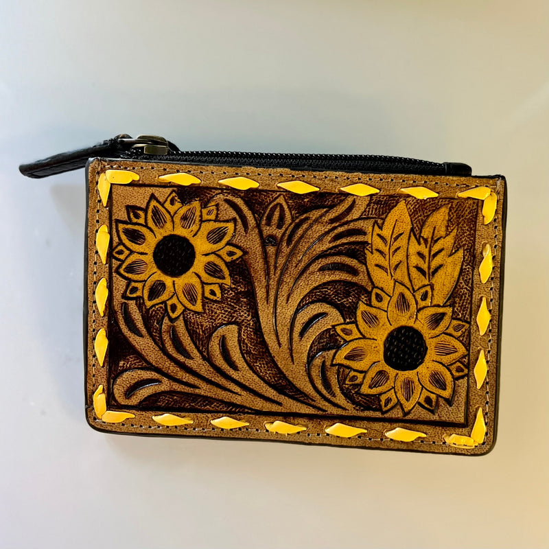 These Beautiful Tooled Leather Credit Card Holders are perfect for a handheld option. They are the perfect size to slip in your back pocket for a shopping day. Feature a zipper pouch for safe keeping, and four card slots. They are Gorgeous Tooled Leather with 2 different variants offered.   Dimensions: 5" X 3"