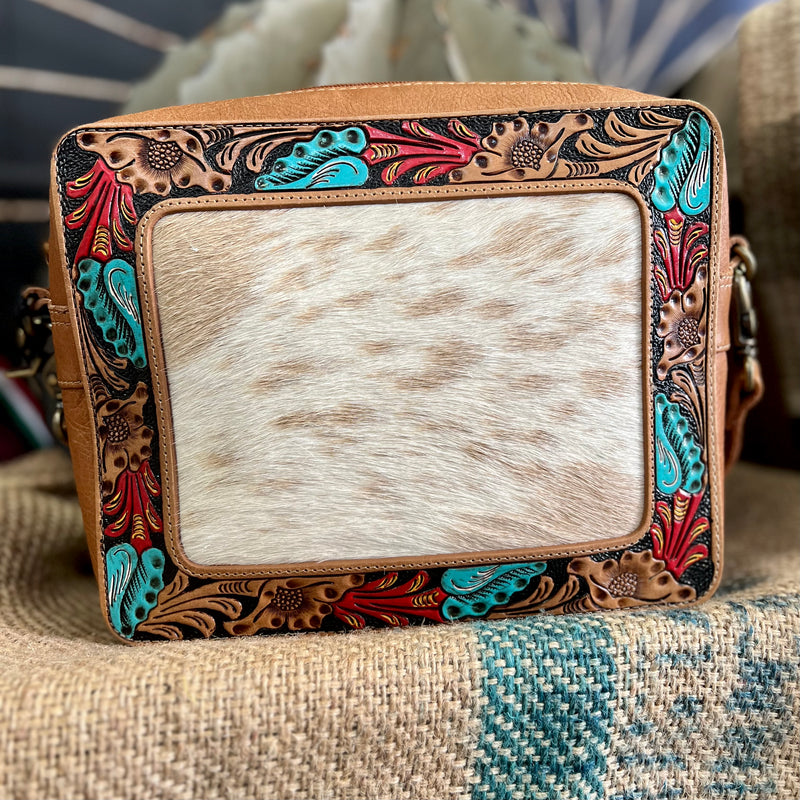 This beautiful Square Garden Bag features a hair on hide frame detail with an intricate turquoise and red painted floral pattern, complemented by brown leather.  With a 44" adjustable shoulder strap, you'll have the convenience and comfort you need to take everything you need on the go.  Dimensions: 10"W X 10"H