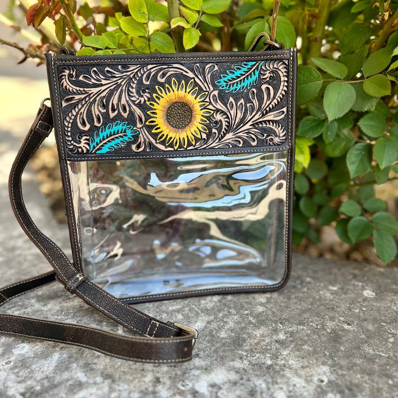 This elegantly crafted, practical Sunflower Fields Clear Bag is made of sunflower tooled and painted brown leather with an adjustable 44" shoulder strap for comfortable wearing. An exquisite accessory for any outfit!  9 1/2"W X 10" H   Wallet sold separately, wallet not included. 
