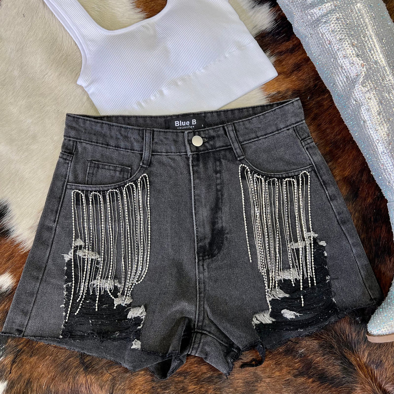 These short are made to be seen and heard! Whether you fancy Coachella or SXSW, you need these bad boys! Black denim high waisted shorts with ripped frayed hem and rhinestone fringe detail around the front pockets.  Rise: 12"  Inseam: 4"  90% Cotton, 10% Polyester