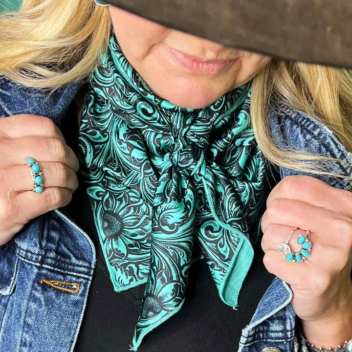 This Gorgeous Sheridan Wild Rag is a Turquoise Black Tooled Print Silk material trimmed in Turquoise. It would compliment any outfit and be a statement piece for sure!  35" X 35" in total size and 48" from corner to corner