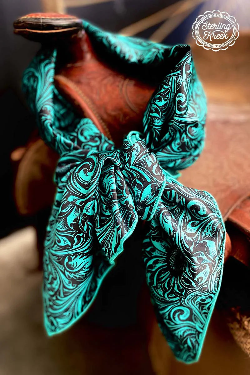 This Gorgeous Sheridan Wild Rag is a Turquoise Black Tooled Print Silk material trimmed in Turquoise. It would compliment any outfit and be a statement piece for sure!  35" X 35" in total size and 48" from corner to corner