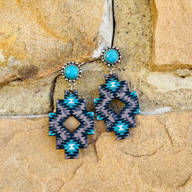 The Aztec Ranch Earrings come in 2 different color options. The Aztec Print on the Wooden Cutout is Perfect. The earrings are a dangle connected to a single turquoise stone on a silver post back. Total length is 3". 
