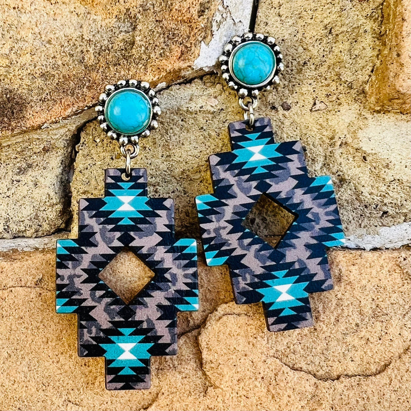 The Aztec Ranch Earrings come in 2 different color options. The Aztec Print on the Wooden Cutout is Perfect. The earrings are a dangle connected to a single turquoise stone on a silver post back. Total length is 3". 