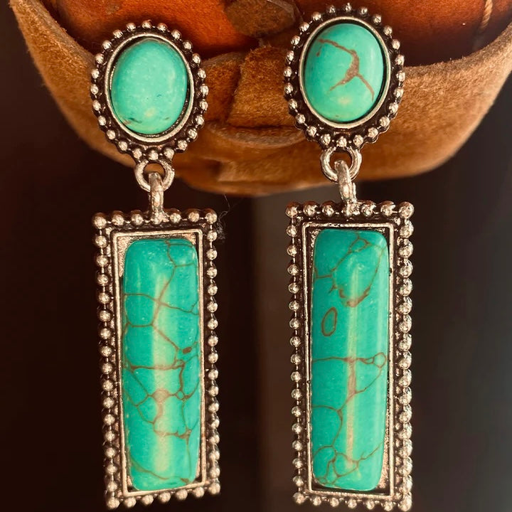 These Sioux River Dangle Earrings are beautiful! They are 2" in total length. The single turquoise stone with a post back is attached to a turquoise and silver bar design dangle
