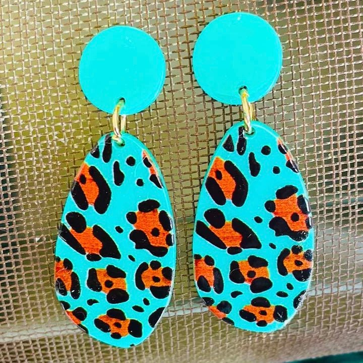 These cool looking Neon Kitty Earrings will add color to any outfit. The turquoise/greenish colored back ground with the leopard detail makes these earrings stand out. The single post back circle attached to the oblong dangle are perfect. 2 1/4" in total length. 