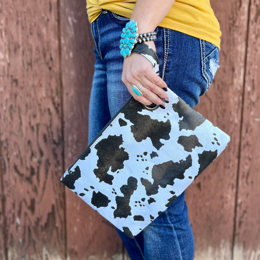 The Dani Cow Wristlet is the perfect size clutch for everyday use. Featuring a full zipper closure, lined inside, and a grommet design wristlet. This wristlet measures 12.2" X 8.6"