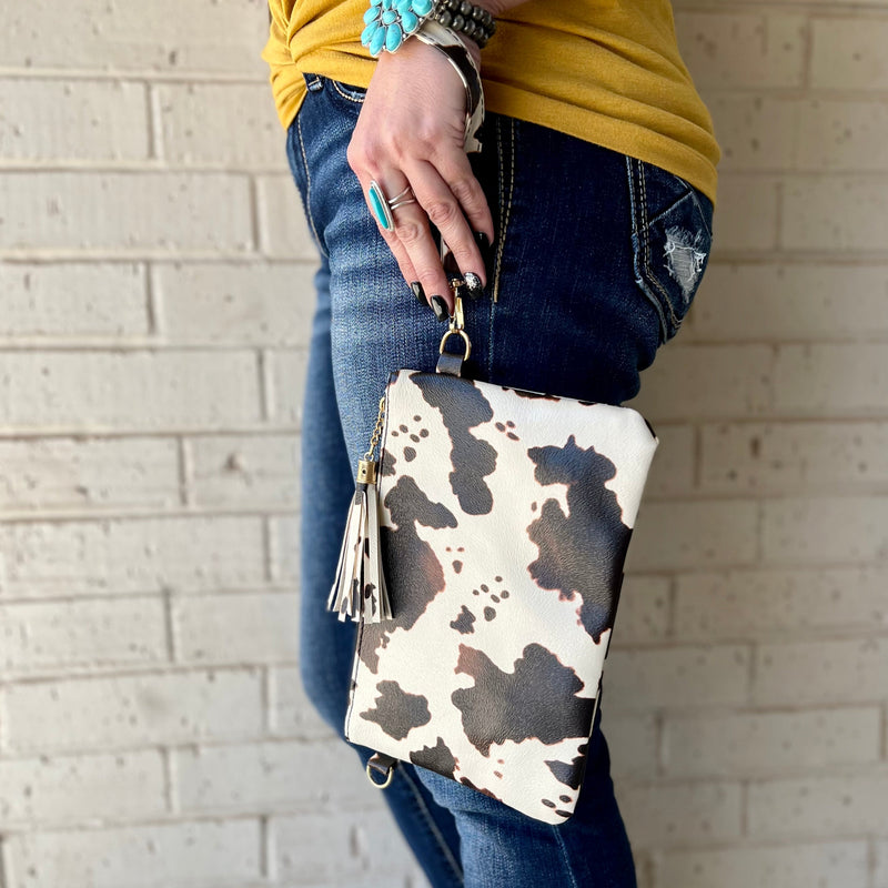 The Arlington Cow Wristlet is the perfect size clutch for everyday use. Featuring a full zipper closure, lined inside, and fringe tassel accent. This wristlet measures 10" X 7".