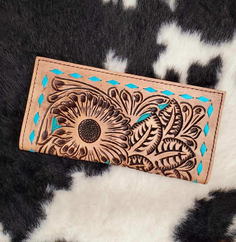 beautiful tan and turquoise tooled leather bi-fold wallet. Accented with turquoise lacing, and a push clasp closure. Plenty of card slots, cash slot, and check book slot.