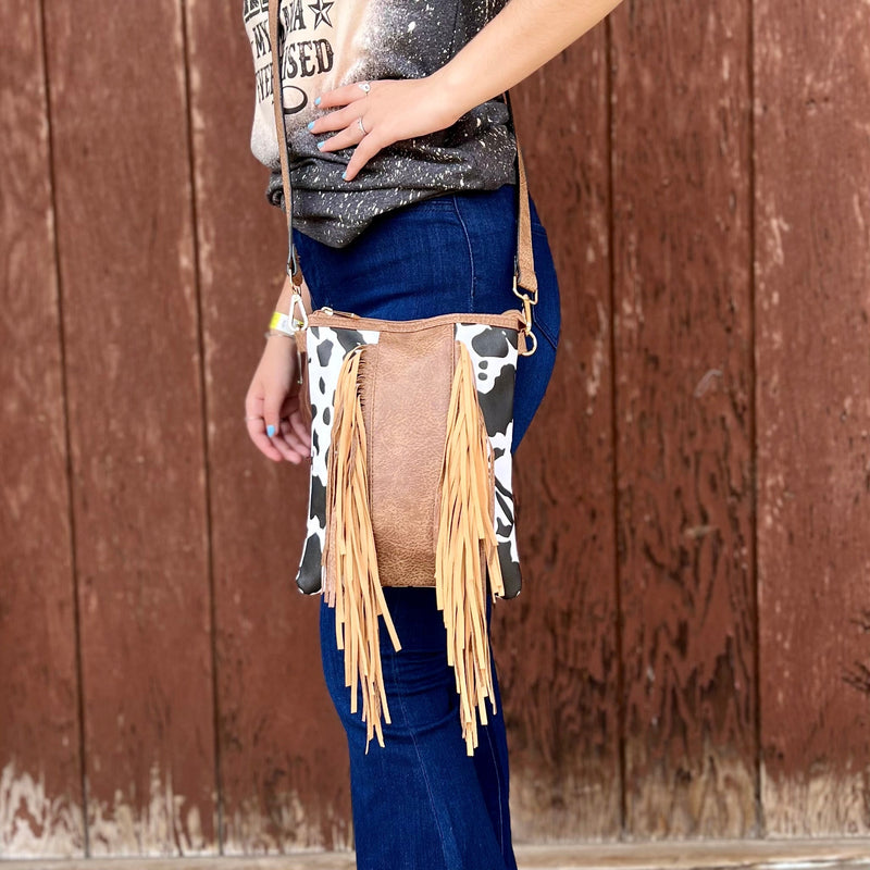This Cow Print Crossbody is the perfect size. The fringe completes the look. It has one large zipper compartment for all your needs.   8"W X 10"H  48" removable strap