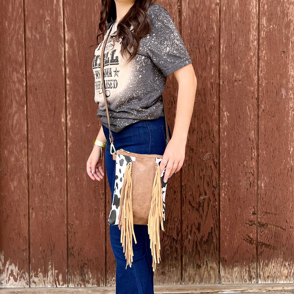 This Cow Print Crossbody is the perfect size. The fringe completes the look. It has one large zipper compartment for all your needs.   8"W X 10"H  48" removable strap