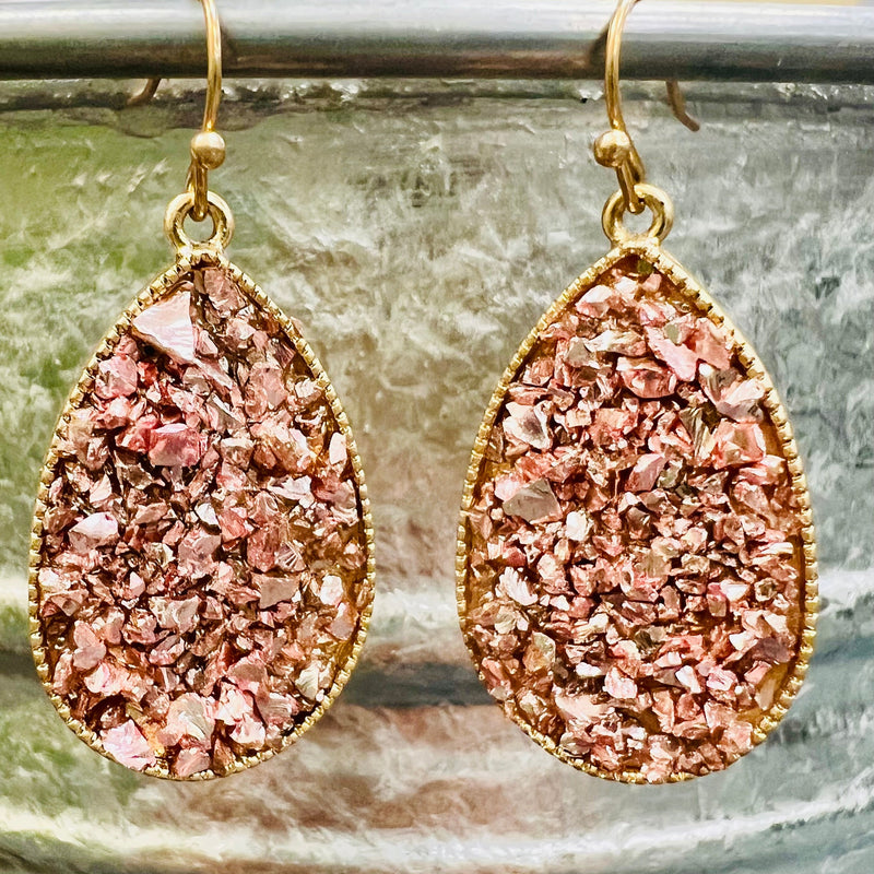 The Bayler Grace Teardrop Earrings are a show stopper. The earrings come in 4 different colors. They are 1 1/4" teardrop with multiple rock gem stones. They are inlayed in a gold tear drop background. They are on a fish hook back.