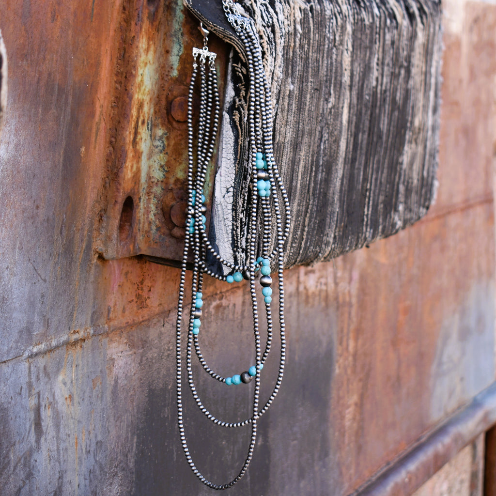 Five strand necklace of pewter beads accented with turquoise beads.