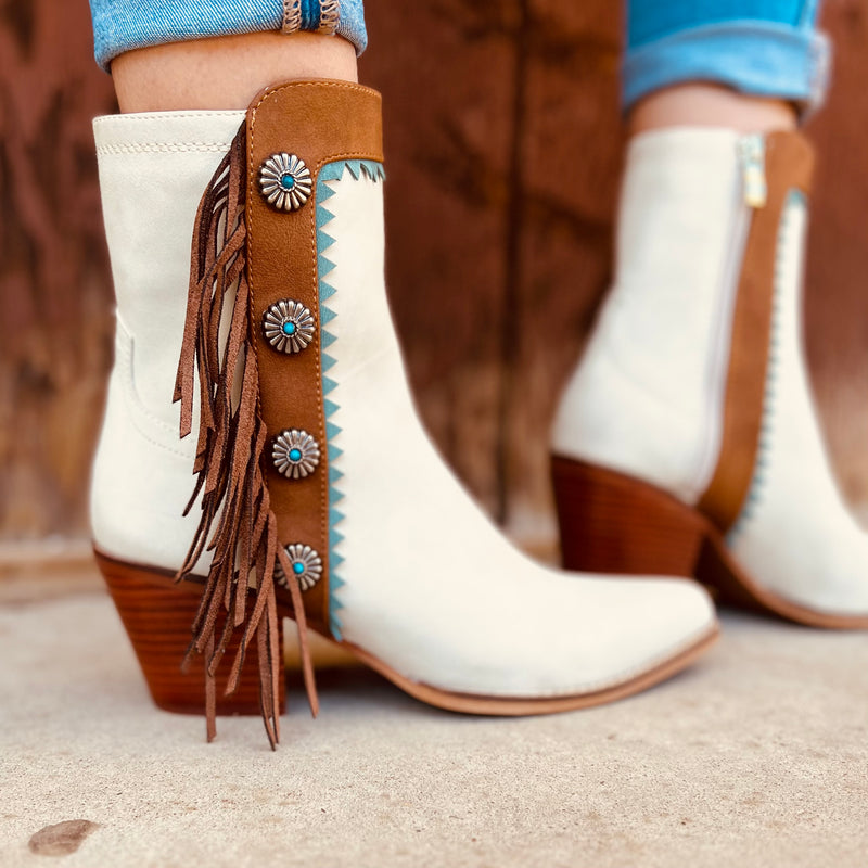 These Gizelle Aztec Tribal Fringe Boots are amazing in person. They are cream/nude colored with turquoise and brown leather accents. They have turquoise and silver flower conchos up the side with the brown fringe make these boots so beautiful. 9" tall boots with a 3" heel, these boots will dress up any skirt or pants.
